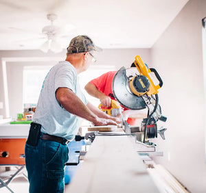Two people using an electric saw to working on a remodel.